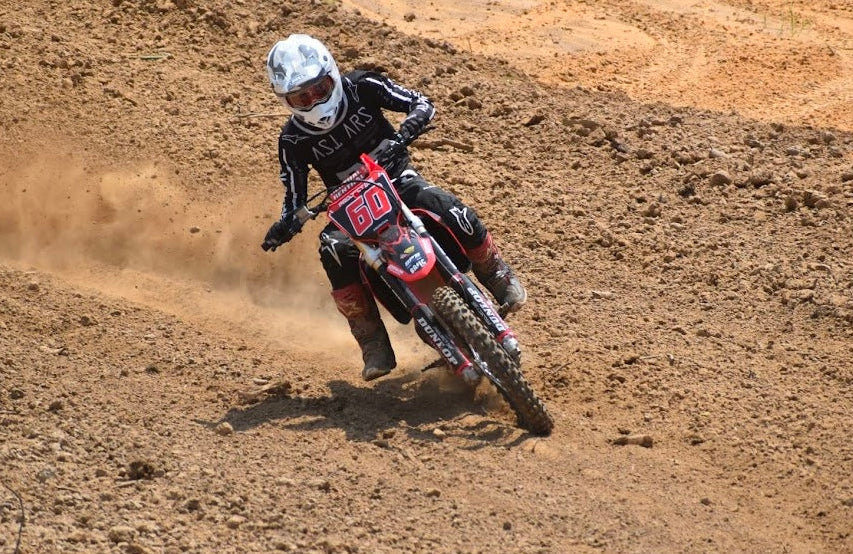 Person riding a dirt bike on a dirt track